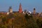 View of the Maastricht skyline during autumn times with trees and the coloured leaves and the towers of the various churches and t
