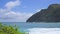 View of makapuu lighthouse. Waves of Pacific Ocean wash over yellow sand of tropical beach. Magnificent mountains of