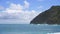 View of makapuu lighthouse. Waves of Pacific Ocean wash over yellow sand of tropical beach. Magnificent mountains of