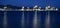 View of Malaga`s port, with lights reflecting in the water surface at blue hour