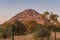 A view of the male hill at Tsodilo Hills, glowing pink during sunset. Tsodillo hills is a UNESCO world heritage site featuring