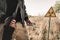 View of man holding radiometer and gun near toxic symbol, post apocalyptic concept