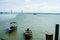 View of a man by the jetty securing rope from his boat to a wooden jetty. view from a wooden jetty