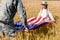 View of man in military uniform holding american flag with cute daughter in field