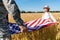 View of man in military uniform holding american flag with daughter in field