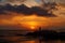 View of a man silhouette standing on sea stone beach and shooting selfie with beautiful amazing sunset of orange red colors. Beaut