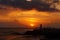 View of a man silhouette standing on sea stone beach and shooting selfie with beautiful amazing sunset of orange red colors. Beaut