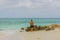 View of man standing on beach and looking on endless ocean. White sand beach and turquoise water merging with blue sky