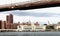 View of Manhattan buildings lining the East River along FDR Drive from beneath the Brooklyn Bridge.