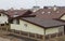 The view of many house roofs covered with bitumen, asphalt shingles, metal and clay tiles with skylights, ventilation caps, and