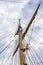 View of the mast of a large sailing ship against the sky with clouds