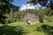 View of a meadow with dilapidated stone hut