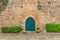 View of the medieval gate door on Luso Roman castle of Ã“bidos, with ceramic pot with plants, in Portugal