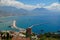 View on a Mediterranean sea coastline in Turkish city of Alanya with foggy mountains under cumulus clouds on the horizon