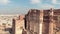 view of Mehrangarh Fort\\\'s facades overlooking the terraces and features surrounded by prey birds - Aerial Orbit shot