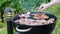 View of men grilling meat steak; sausages and onions outdoors on a summer day. Healthy food concept.