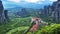 View of Meteora valley at daytime, with far sunrays and beautiful clouds, over Rousanou nunnery and St Nicholas Anapausas monaster