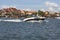 View from MikoÅ‚ajskie Lake of town, motorboat sailing on the lake, Mikolajki, Masuria, Poland