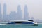 View of a modern ferry of Dubai water public transportation connecting several districts within Dubai. Business Bay in background.