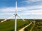 view of a modern windmill against a blue sky. The white blades of the wind turbine close up. Renewable energy source. Production