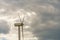 view of a modern windmill against a blue sky. The white blades of the wind turbine close up. Renewable energy source. Production