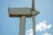 view of a modern windmill against a blue sky. The white blades of the wind turbine close up. Renewable energy source. Production