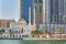 View Mohammed Bin Ahmed Al Mulla Mosque against the backdrop of residential skyscrapers on waterfront of Dubai Marina.