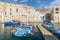 View of Monopoli harbor with colorful azure fishing boats, Apulia, Italy