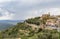 View of the Montalcino Cathedral and houses on the hill, fortress wall around the town and surroundings of Montalcino, Tuscany