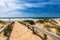 View of the Monte Clerigo beach with flying seagulls on the western coastline of Portugal, Algarve. Stairs to beach Praia Monte