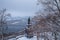 View of the monument to Vladimir the Holy through snow-covered trees in Vladimirsky park and view of the Dnieper river