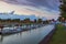 View of the mooring of small boats in the town of Podersdorf on Lake Neusiedl in Austria. In the background is a dramatic sunset