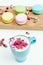 View on morning french macarons and a blue cappuccino cup with rose petals