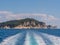 View from a motor boat leaving behind a mountainous island