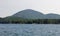 View of Mount Desert island surrounded with trees against a white sky in Hancock County, Maine, USA