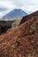 View of Mount Ngauruhoe - Mount Doom from Tongariro Alpine Crossing hike with clouds above and red crater in foreground