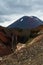 View of Mount Ngauruhoe - Mount Doom from Tongariro Alpine Crossing hike with clouds above and red crater in foreground