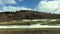 View of mountain from the car window. Mountain in early spring, snow and green grass against blue sky.