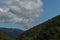 View of mountain forest landscape under sunlight in the middle of the summer with heavy blue sky as a background.