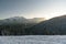 View of the mountain Kitzsteinhorn in the background in winter with trees in the foreground. View from Keilberg, SchmittenhÃ¶he,