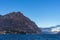 View of mountain lake and hills on shore with buildings during daytime