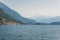 view of mountain lake and hills on shore with buildings during daytime Lake