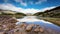 View of a mountain lake with moving clouds