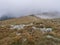View of mountain meadow, grassy hills with footpath of hiking trail in a dangerous thick fog with almost zero visibility