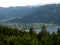 view from the mountain over coniferous forest on an idyllic lake in the valley with village 7
