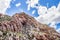 View of a Mountain range with large red rocky outcrops covered with lush green vegetation, Montagu Springs