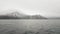 View on mountain with snowy peaks and sea. Sea ship sailing past snowy mountain