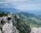 View from the mountain to the cliff. Below is a large forest and meadow. Far away sea and mountains.