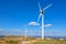 View of a mountains landscape with road and wind turbines on top