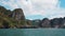 View from the moving boat on sea, coast and cliffs covered by tropical greenery in Krabi